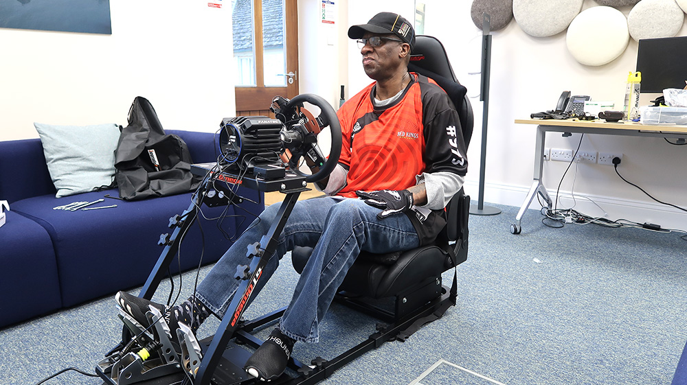 Man seated in full video game racing setup