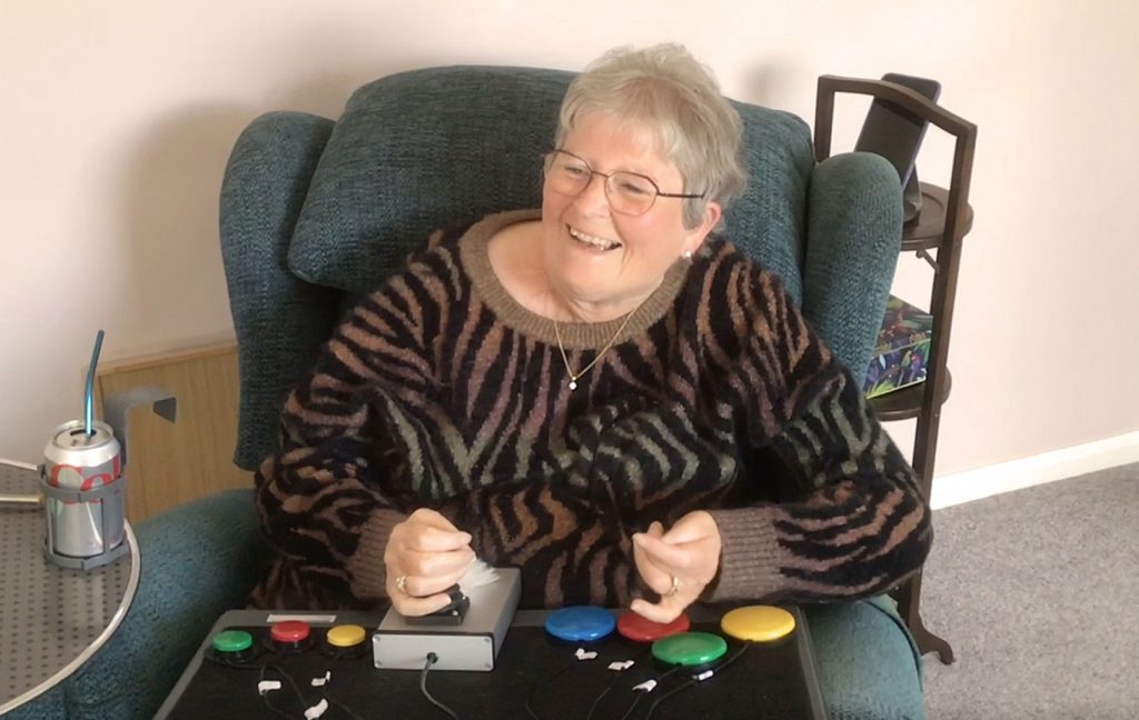 Lady in armchair using an adapted gaming setup