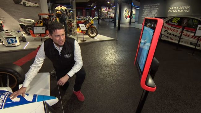 Man showing racing car to a robot