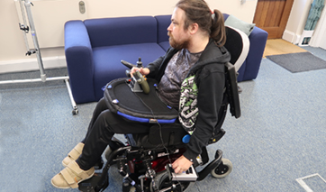 Man in wheelchair using adapted gaming controllers
