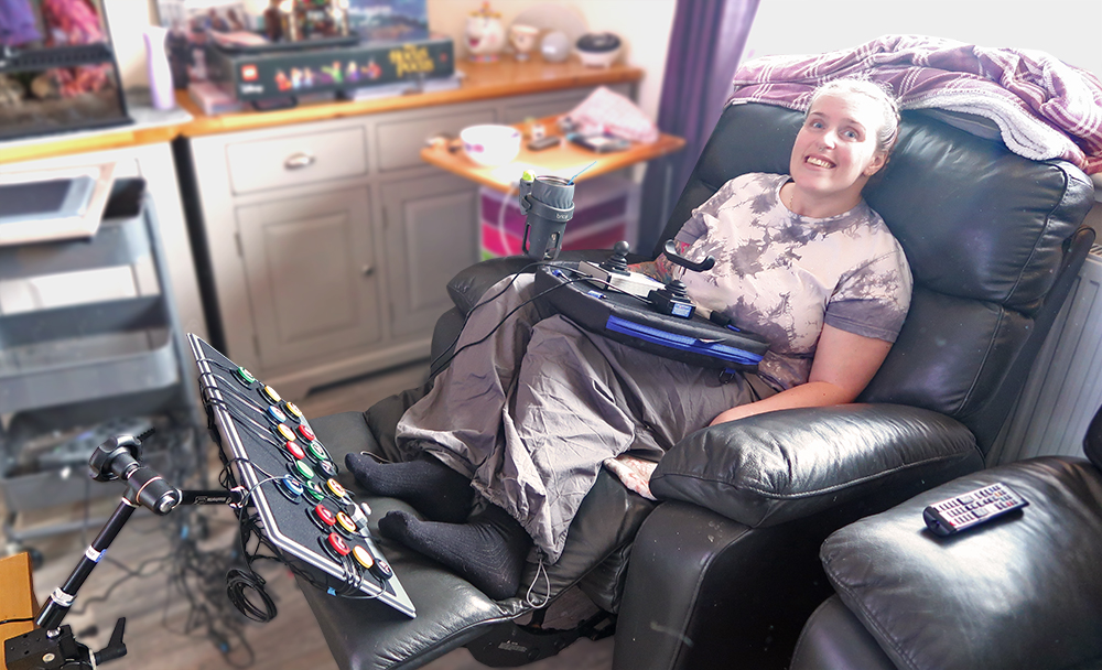 reclining woman with button board at feet and laptray with game controllers