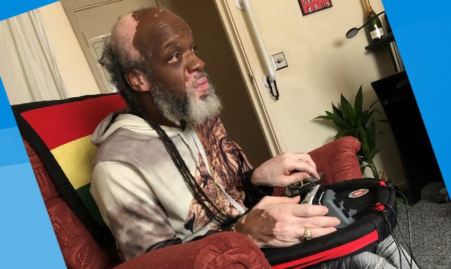 Seated man using adapted gaming setup