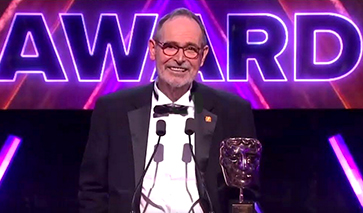 Smiling man in black tie at awards podium